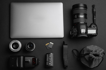 Flat lay composition with photographer's equipment and accessories on black background