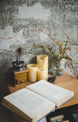 open book, coffee grinder on wooden table, focus on candles