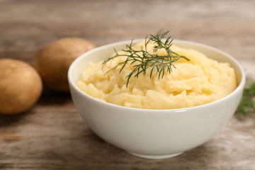 Bowl with mashed potatoes on wooden table
