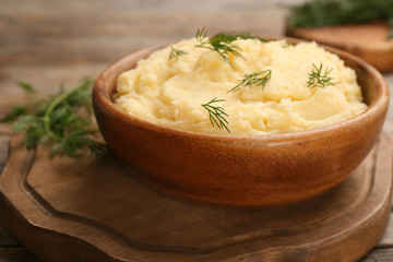Bowl with mashed potatoes on wooden board