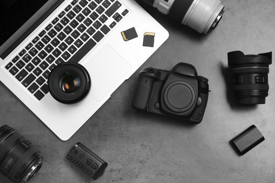 Professional photographer equipment and laptop on gray background, top view