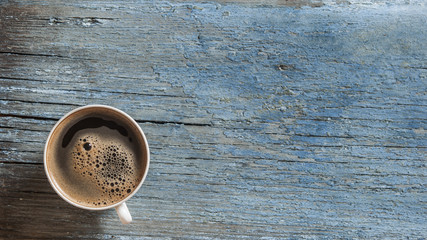 Top view of coffee cup on a wood background with copy space.