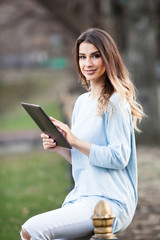 Beautiful woman using tablet outdoors