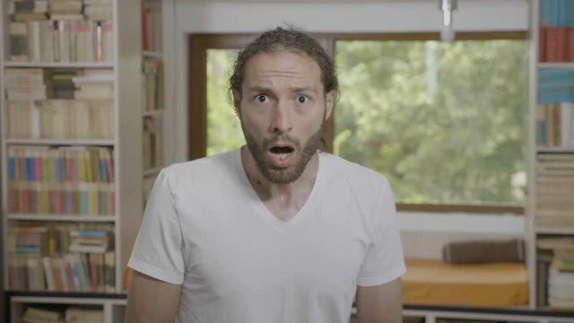 Jaw dropped hipster young bearded man having surprised reaction seeing something astonishing