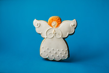 Christmas New Year holiday background, angel gingerbread cookie on blue background. Copy space holiday concept