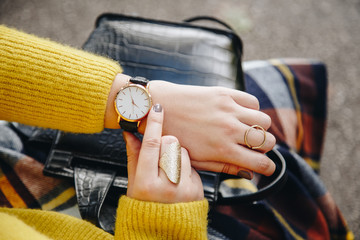 street style fashion details. close up, young fashion blogger wearing a sweater and a analog wrist...