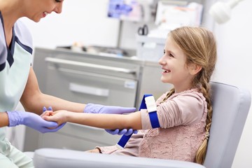 Brave little girl having blood collection for tests