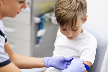 Brave little boy having blood collection for tests
