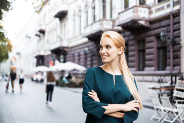 Fototapeta premium Portrait of happy business woman looking confident. Europian street, she walking alone after work meeting conference, waiting for her business partner