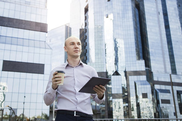 Businessman using cell tablet outdoors