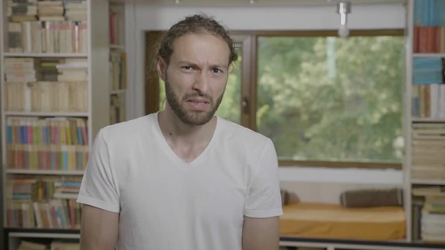 Disgusted hipster saying and expressing damn having a pissed reaction seeing something offending at home