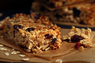 Homemade granola bars with nuts and cranberries over black background