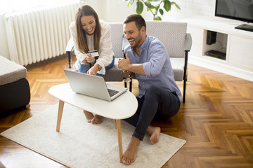 Cheerful couple searching internet and  shopping online