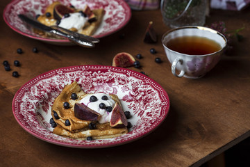 Homemade crepes with fresh figs blueberries and sour cream