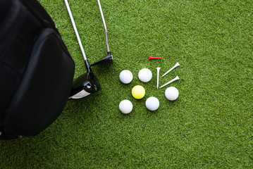 Different golf clubs, balls and tee on the green grass background.Golf set concept.Sport equipment.