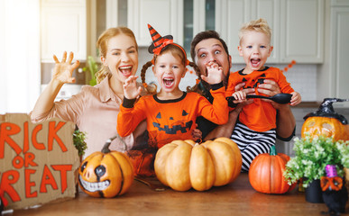 Fototapeta premium happy Halloween! family mother father and children cut pumpkin for holiday home.
