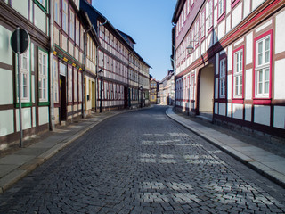 Fototapeta na wymiar Wernigerode, Germany. Road signs and street lamps on a winding street. Deserted alley in the morning