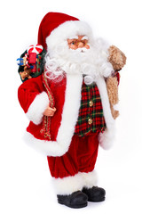 Cute old Santa Claus doll with gifts. Adorable grandfather frost toy holding Christmas presents and plush teddy bear standing isolated on white background. Christmas and New Year symbol figure.