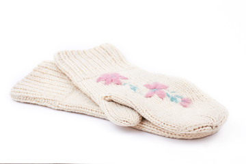 Fototapeta na wymiar White woman knitted mittens, white background. Pair of female warm mittens with a flowers embroidery isolated on white background. Ladies winter handmade fashion accessory.
