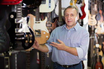 male is standing with modern guitar