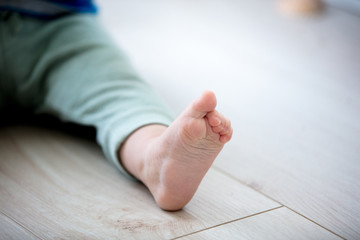 little boy foot in pants on floor. Coseup view