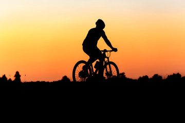 Fototapeta na wymiar Silhouette of cyclist on the background of beautiful sunset