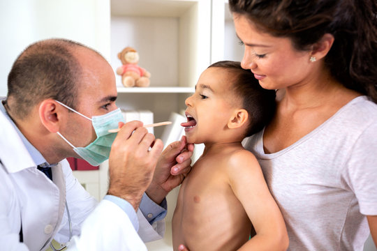 Pediatrician checking his patient throat