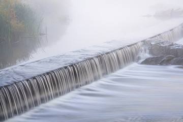 Mornig fog over a river dam