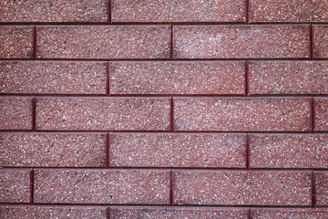 The wall of maroon facing bricks. Background and texture
