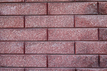 The wall of maroon facing bricks. Background and texture