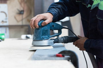 Furniture production or craft concept: worker polishing the stone surface of furniture part with...