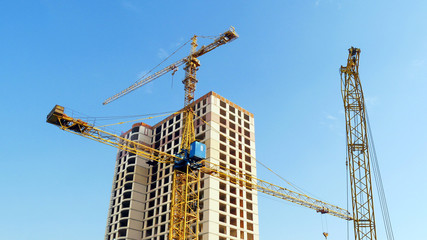 Three cranes near building. Construction site background.