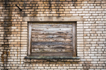 Boarded window on brick building