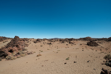 desert landscape with volcanic rocks and clear blue sky copy space -