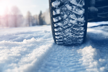 Closeup of car tires in winter on the road covered with snow