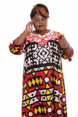 Studio shot of fat black African woman standing while talking on