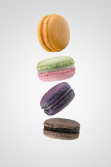 Colorful french macarons floating on white background