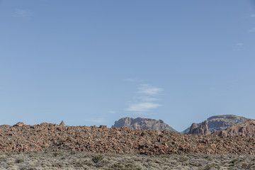 Beautiful landscape of volcanic lava and view of mountains in the background in the Teide National Park on a sunny day, Tenerife, Canary Islands