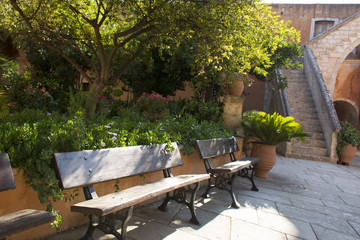 Benches in monastery of Agia Triada, Crete, Greece. Stone stairs on background