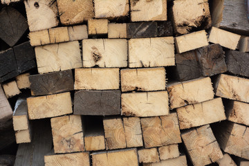 Firewood in woodpile, prepared for Winter. Pile of firewood. The firewood background. A stack of neatly stacked, dry firewood outdoors.