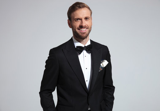 portrait of a relaxed laughing young elegant man in tuxedo