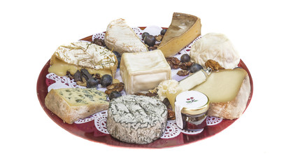 Beautiful cheese plate with various of traditional french cheeses decorated with nuts,grapes isolated on a white background