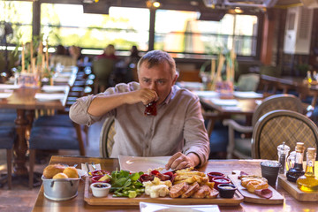 young male eats breakfast in restaurant