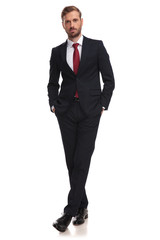 relaxed businessman standing with hands in pockets and legs crossed