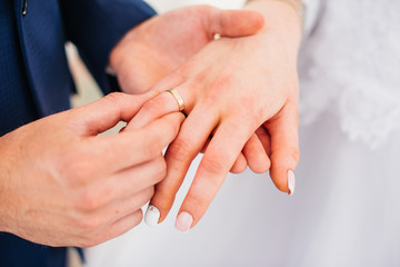 wedding rings on hands of bride and groom