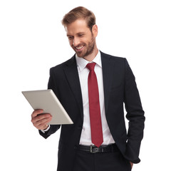 portrait of relaxed and joyful businessman looking at tablet