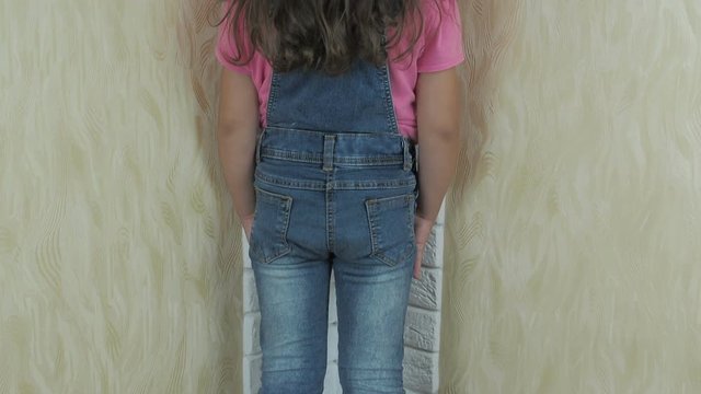 A child in the corner. Little girl begs for forgiveness.