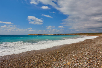 Beautiful wild beach with clear turquoise water and waves.