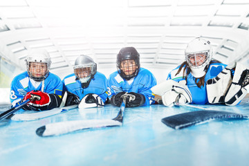 Young hockey players laying on ice rink in line