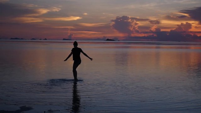 Dancing in the water, a young girl enjoying life in the evening at sunset. slow motion, 1920x1080, full hd